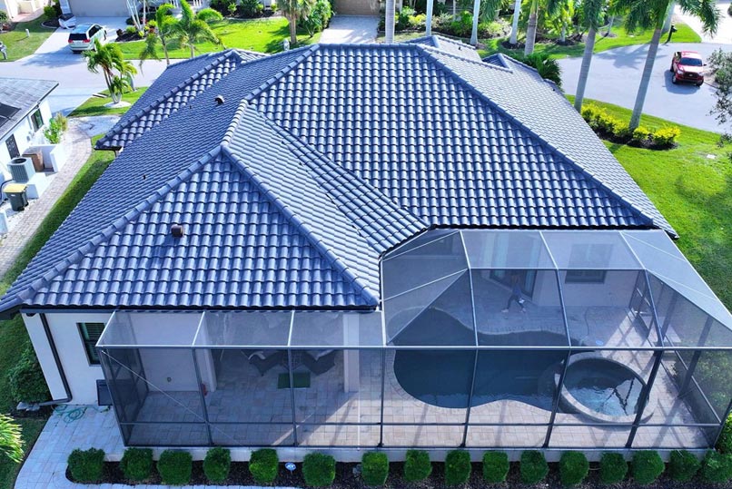 A house with a tile roof and a screened-in pool area.